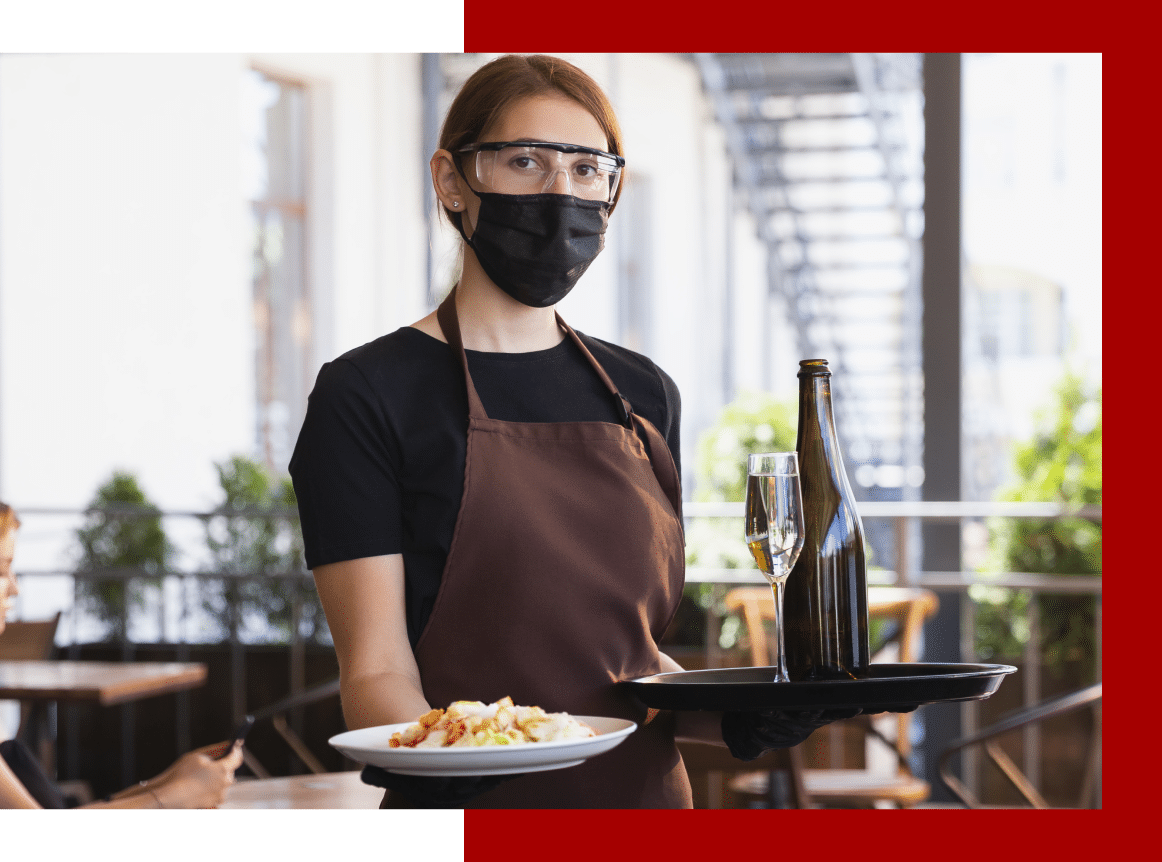 advance-safety-image Food server carrying food while wearing a face mask and protective glasses.
